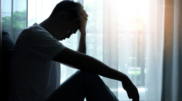 The man sitting in the corner of the room has emotional and mental problems He has depression and stress from society and work. medical concept.